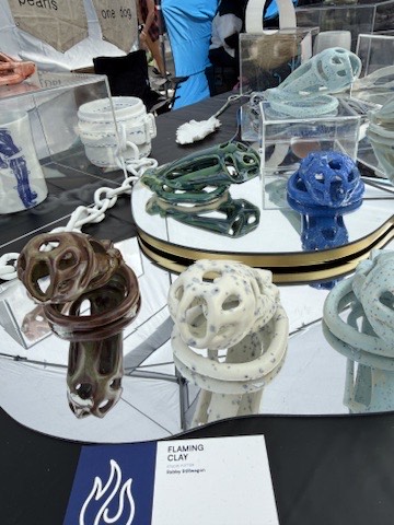 Flaming Clay table at Folsom Street Fair: glazed cage sculptures on a mirrored stand